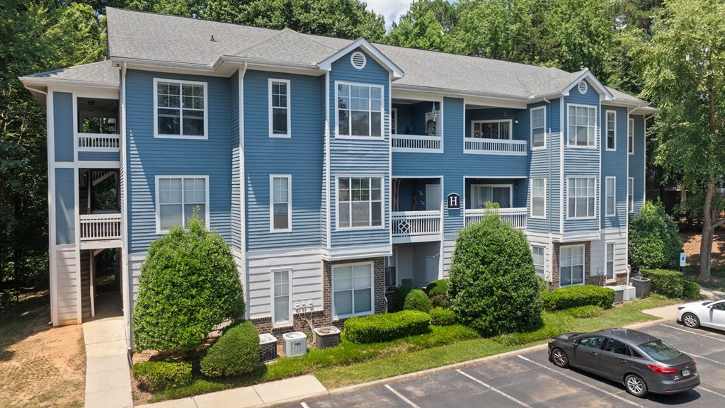 a blue apartment building with cars parked in front of it