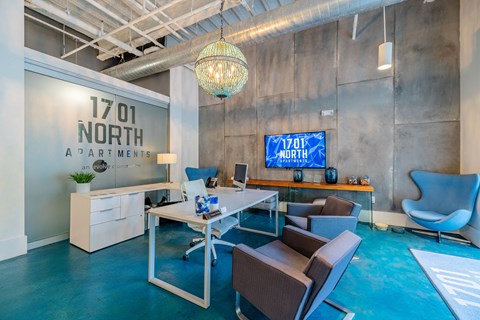 A modern office space with a blue floor and a television mounted on the wall.