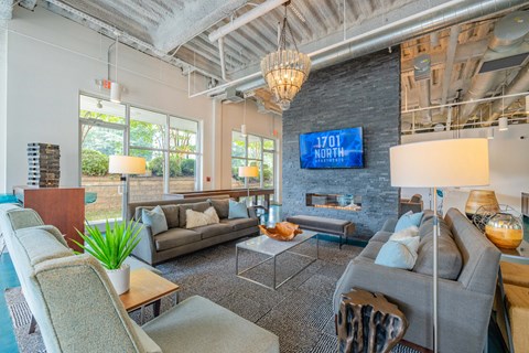 A living room with a grey couch and a fireplace.