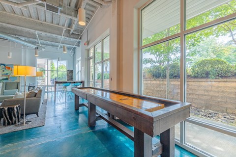 A pool table in a room with a view of a rocky landscape outside the window.