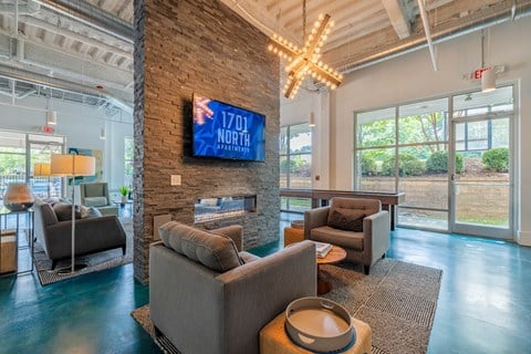 A living room with a stone pillar and a flat screen TV mounted on it.