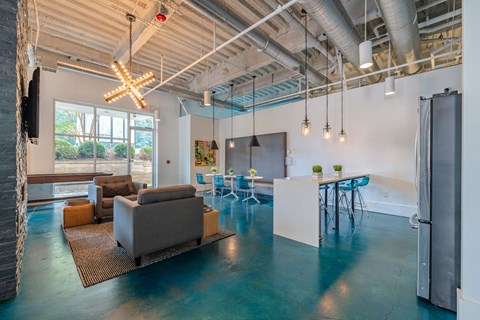 A modern open plan living and dining area with a kitchen in the background.