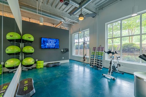 A gym with exercise equipment and a TV displaying "1701+ NORTH".