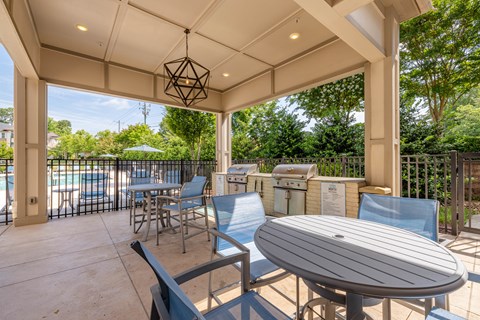 A patio with a table and chairs under a roof.