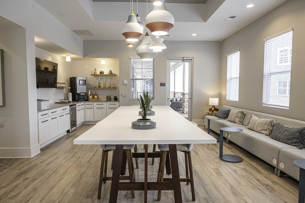 an open kitchen and living room with a large white table