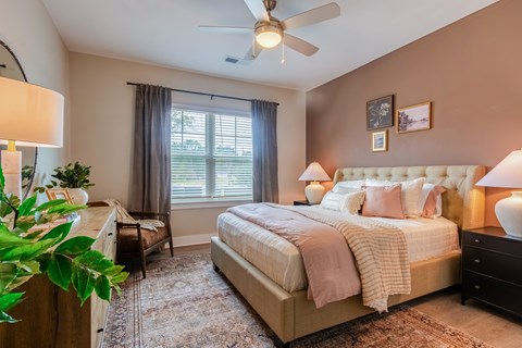 Bedroom with a Large Bed, Two Nightstands, Dresser and a Ceiling Fan.