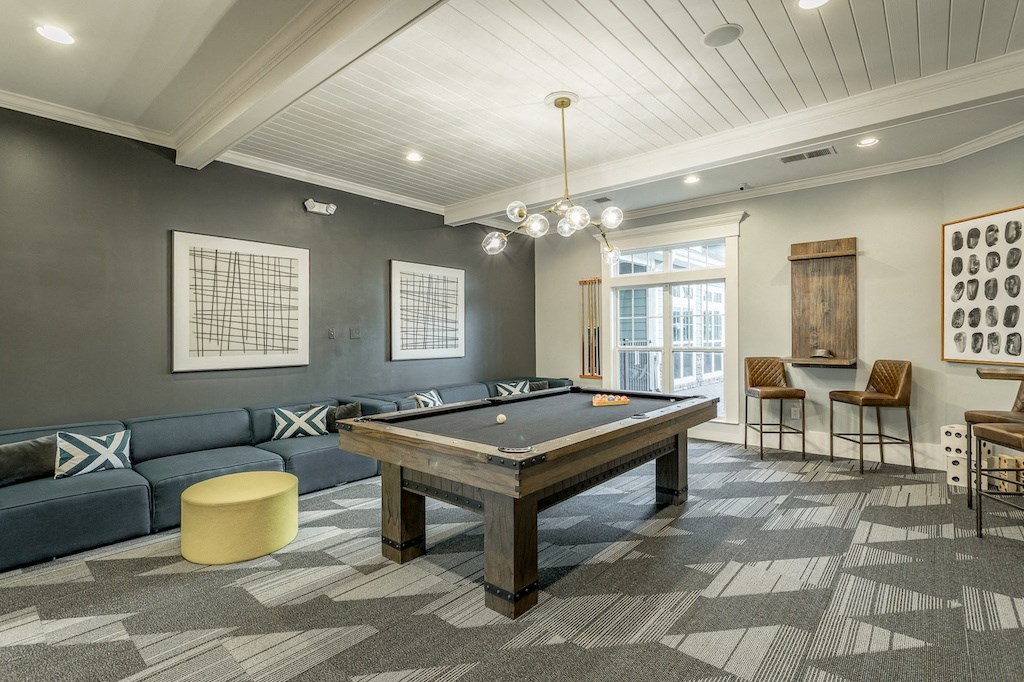 a spacious game room with a pool table and a bar
