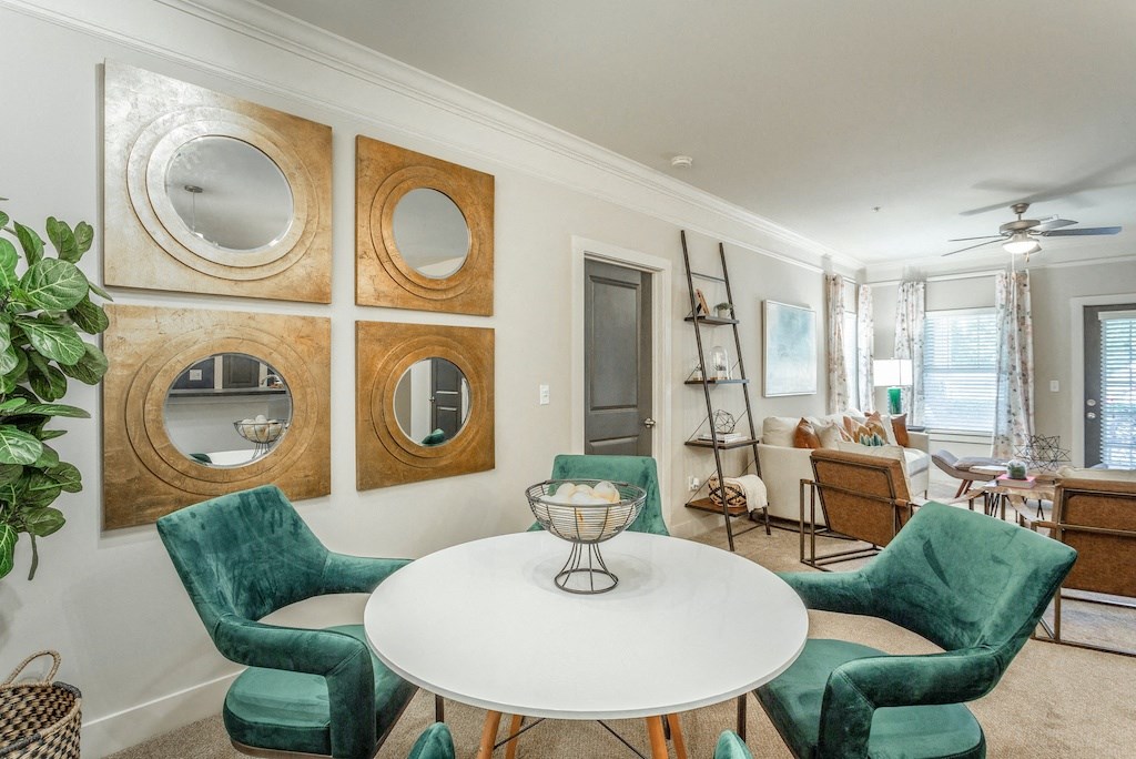 a living room with green chairs and a white table