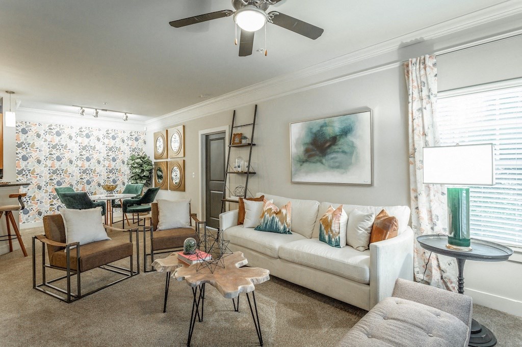 a living room filled with furniture and a ceiling fan