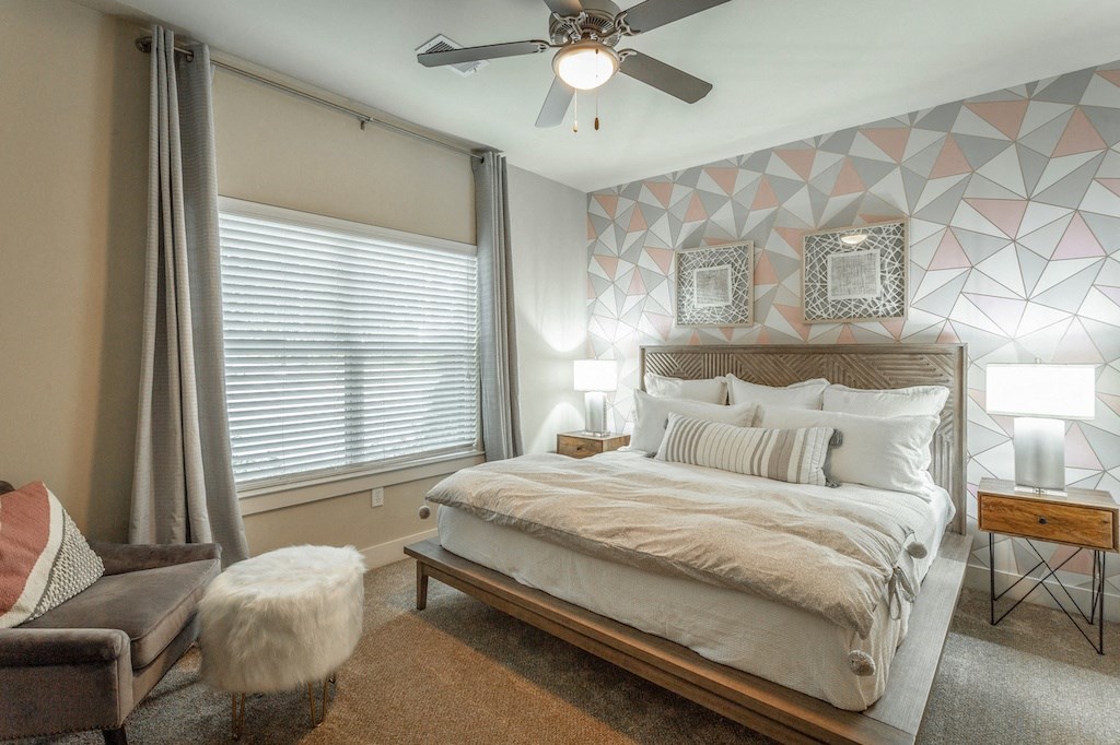 a bedroom with a large bed and a ceiling fan