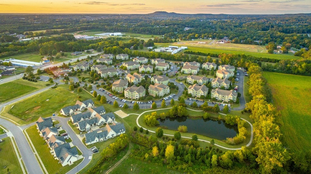 an aerial view of a neighborhood with a large pond in the middle