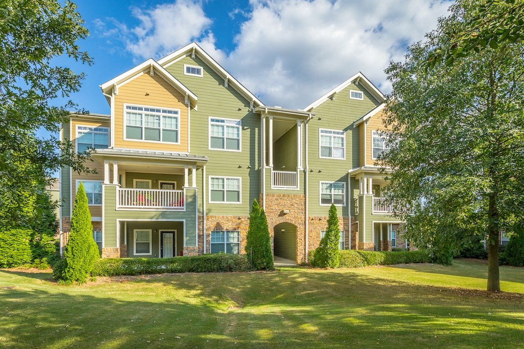 a large apartment building with a lawn in front of it