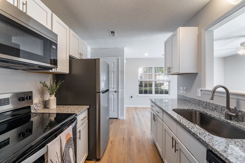 A kitchen with a black stove top oven and a black microwave.