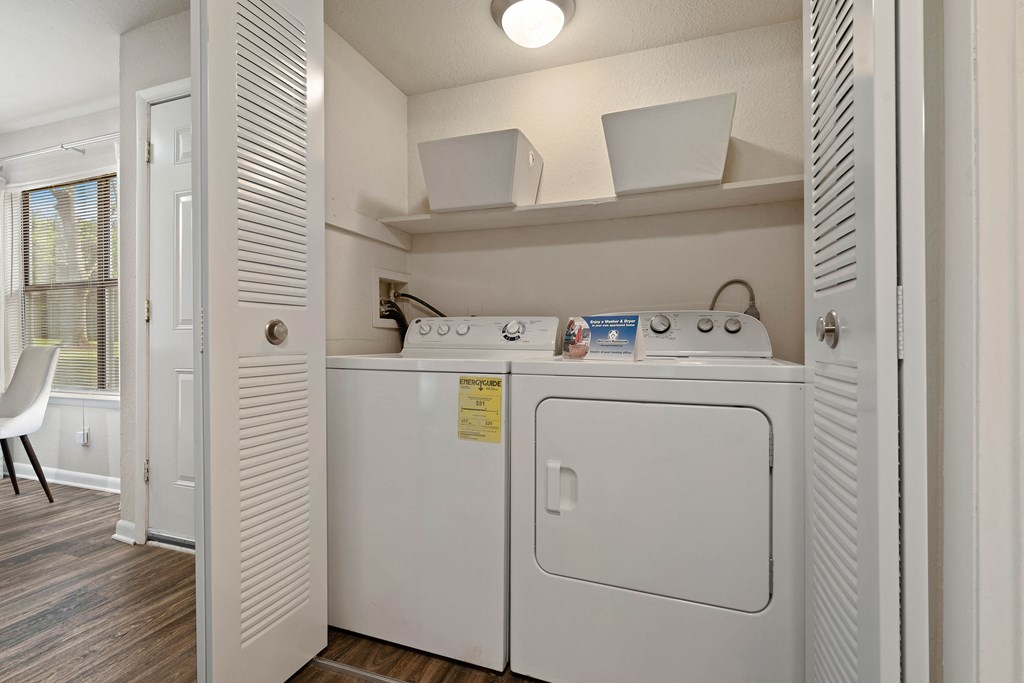 a washer and dryer in a laundry room with a door to a closet