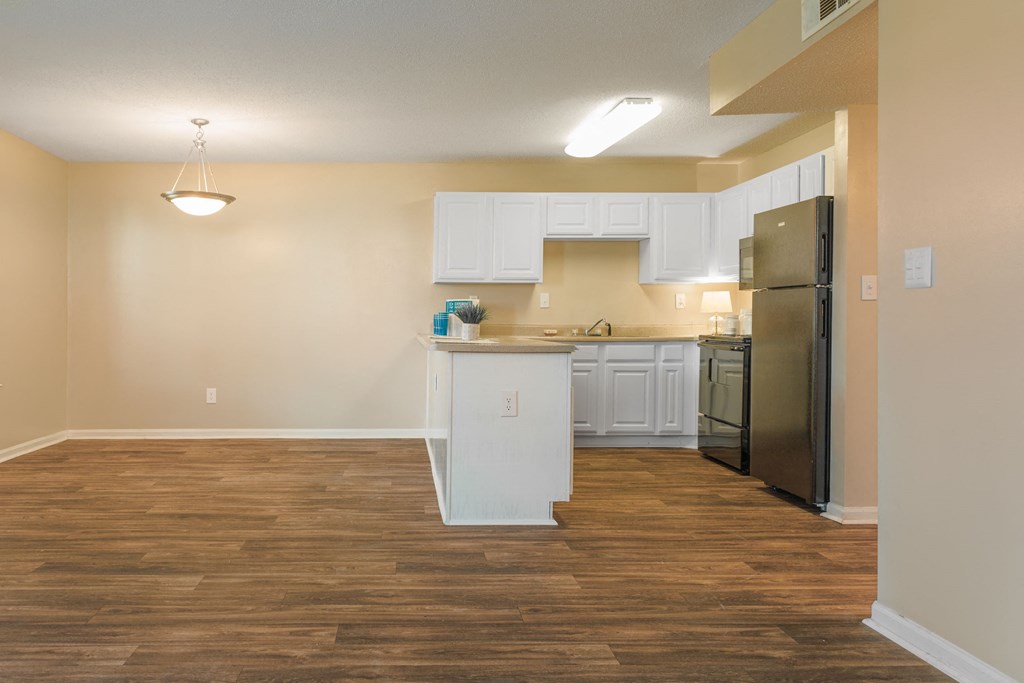 a kitchen and living room with a wooden floor