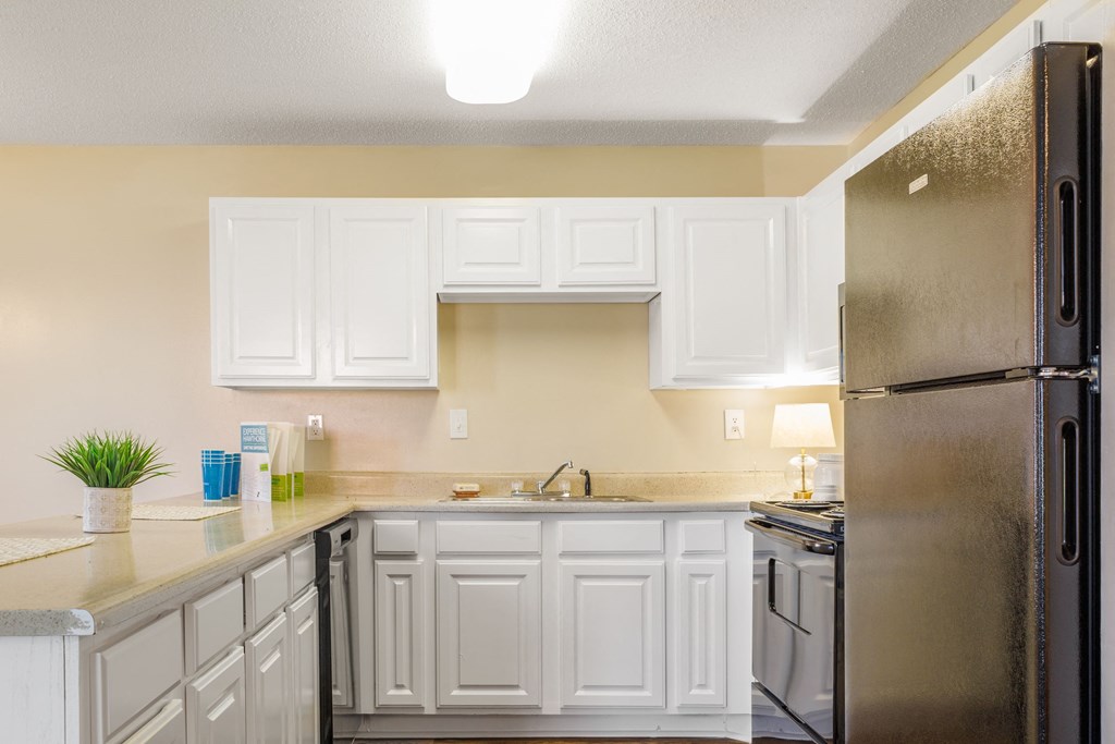 a kitchen with white cabinets and black appliances