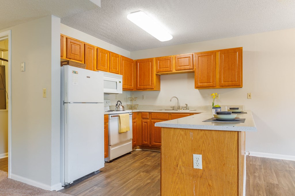 a kitchen with white appliances and wooden cabinets