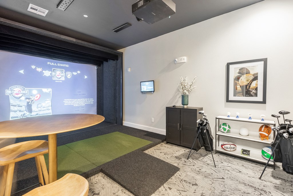 a room with a projector screen and a table and chairs