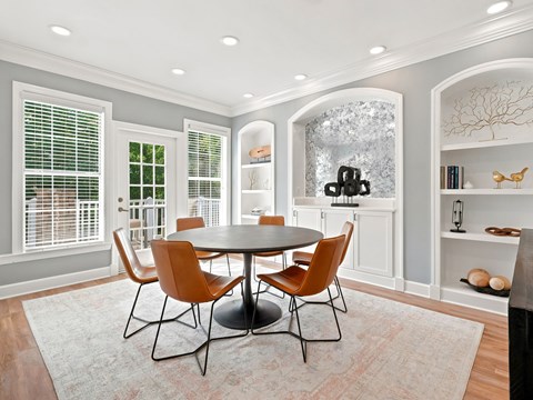 A dining room with a round table and chairs.