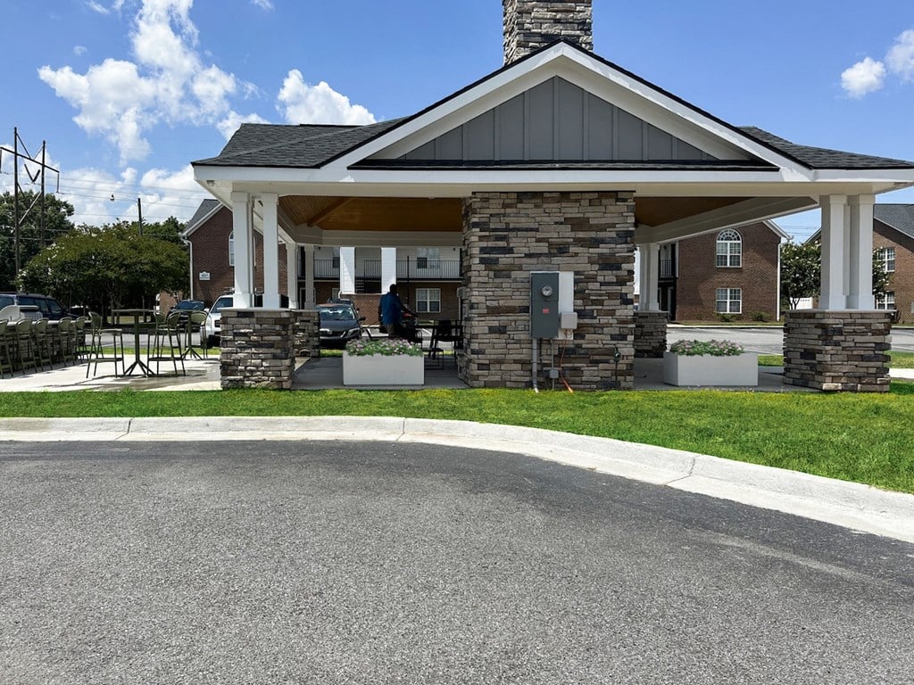 a view of the front of a building with a porch and a driveway