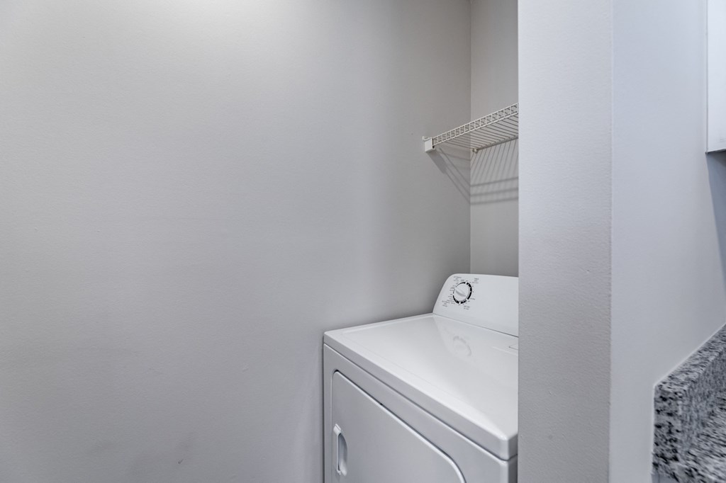 A white washing machine in a small laundry room.