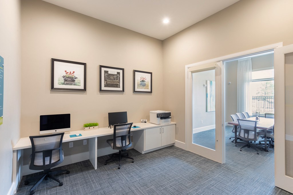 an office with two desks and chairs and a window