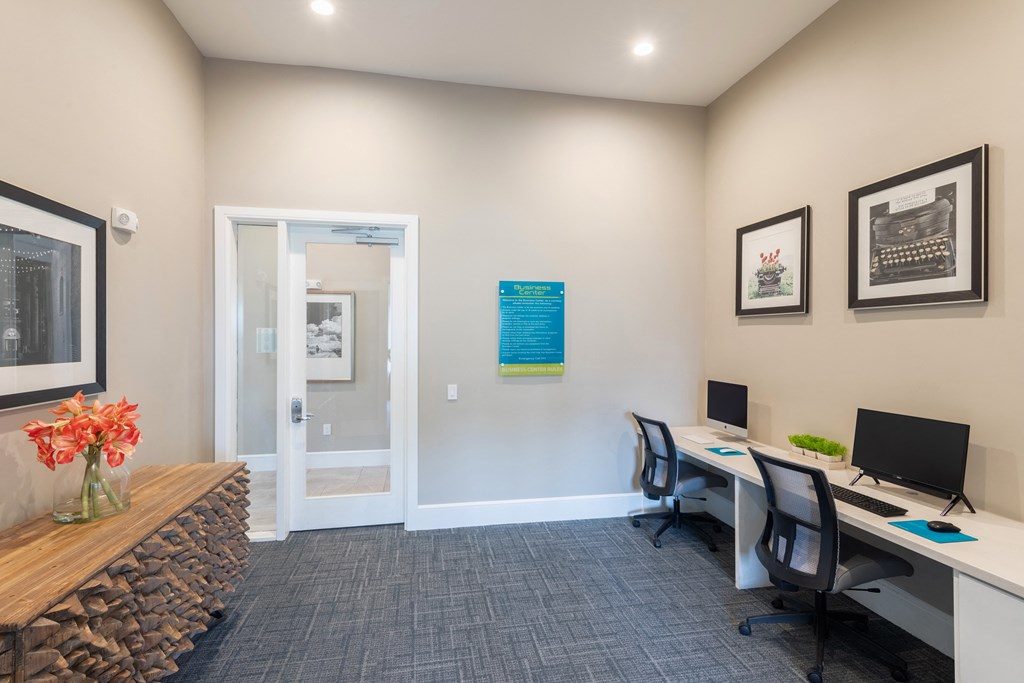 a office with two desks and two chairs and a doorway