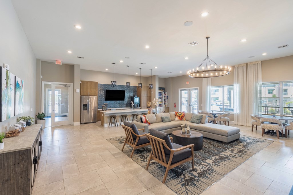 a living room with couches and chairs and a kitchen with a television