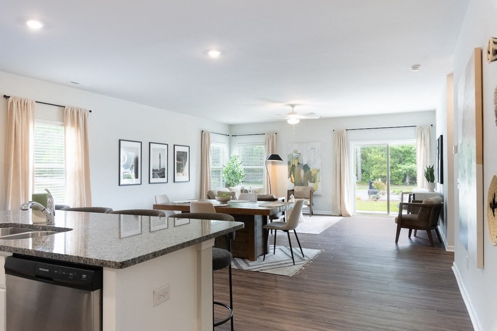 the view of a living room and dining room from the kitchen of a house