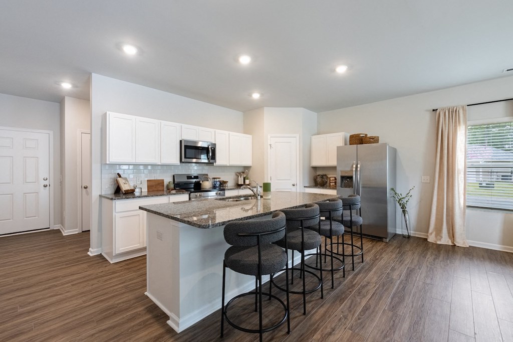 an open kitchen with a large island with bar stools