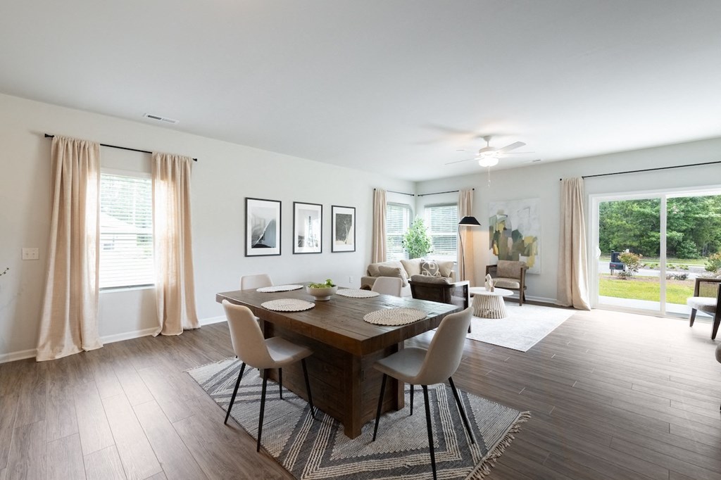 a dining room and living room with a wooden table and chairs