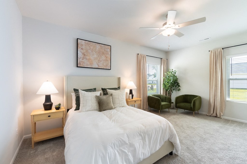 a white bedroom with a white bed and a ceiling fan