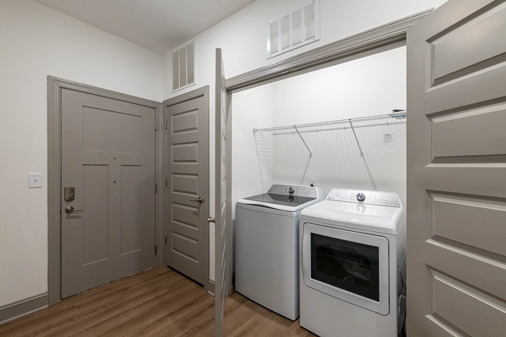 a white washer and dryer in a room with a door