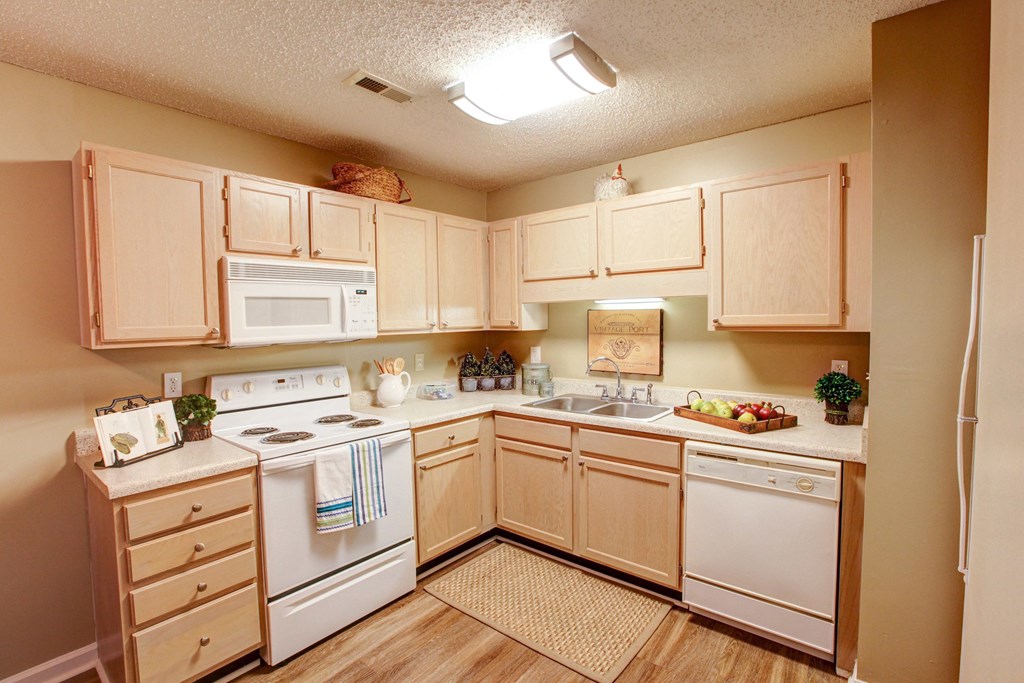 a kitchen with white appliances and wooden cabinets