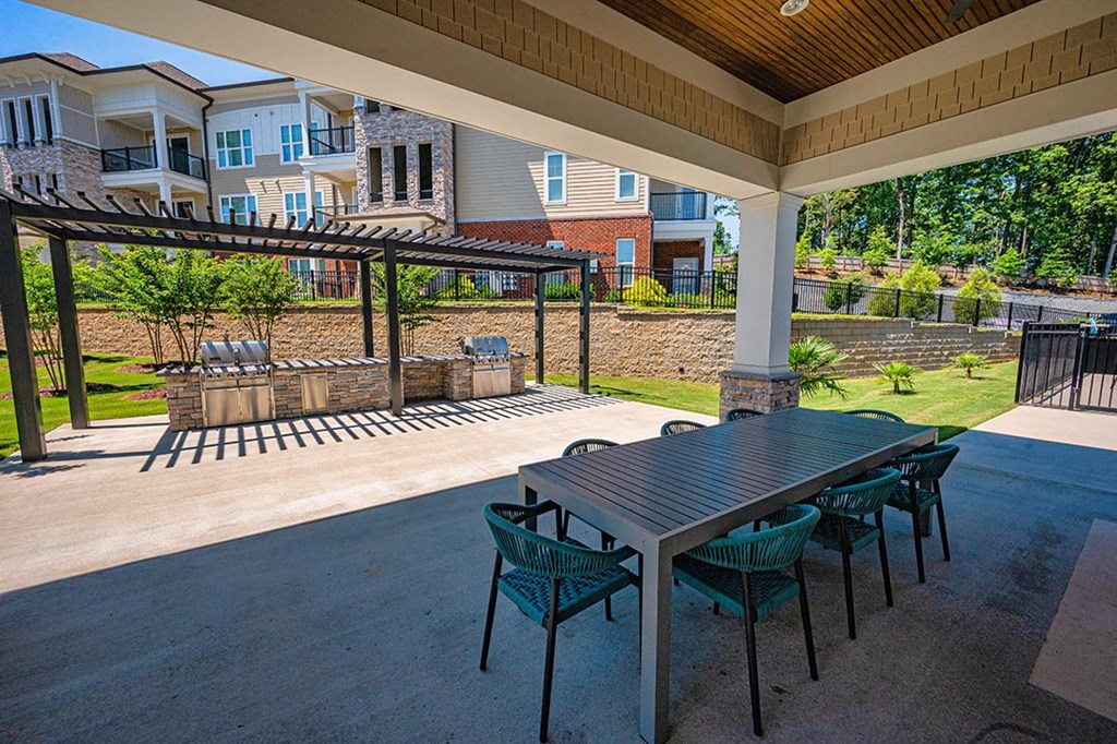 a covered patio with a table and chairs