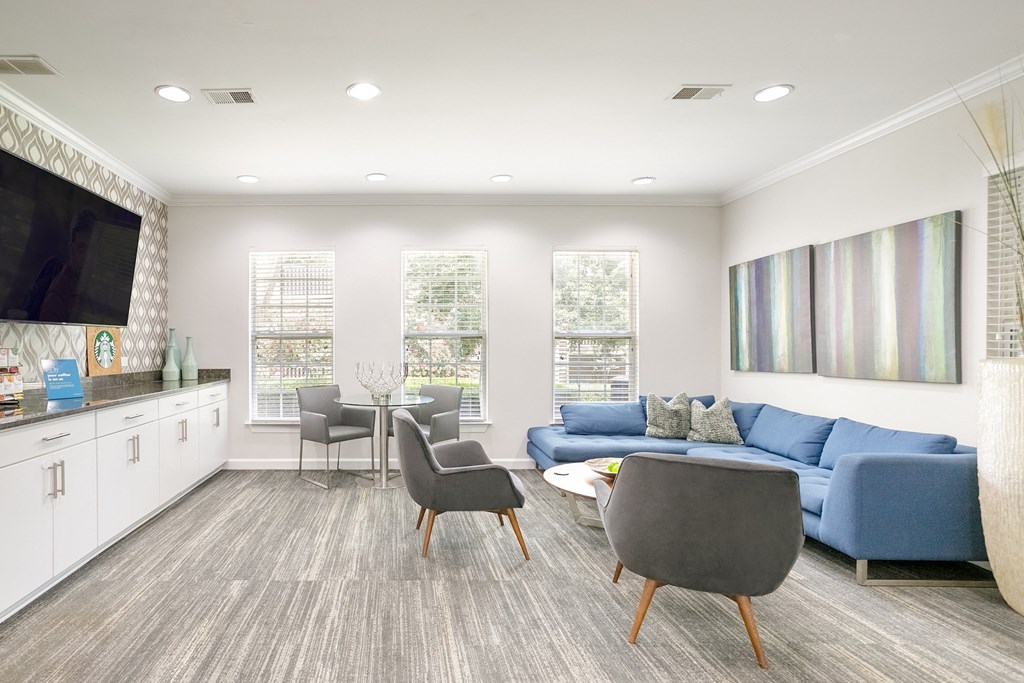a living room with a blue couch and a table and chairs