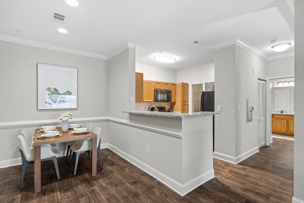 a dining room and kitchen with a table and chairs
