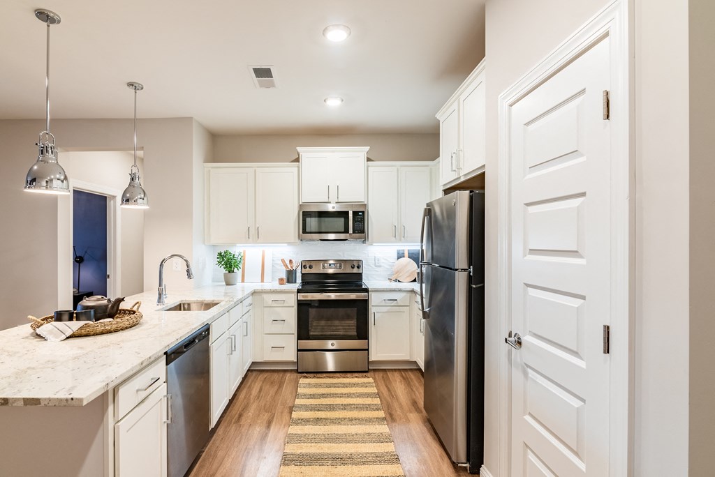 a large kitchen with white cabinets and stainless steel appliances