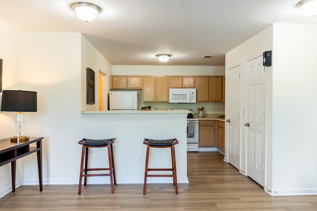 a kitchen and living room with two stools