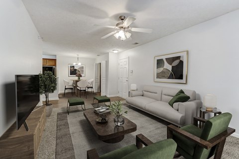 A living room with a couch, chairs, and a television.