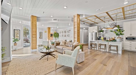 A modern open-plan living and kitchen area with a dining table set for four.