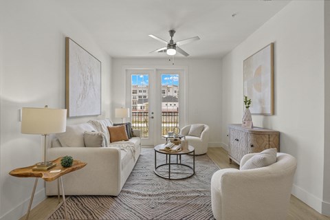 a living room with couches and chairs and a ceiling fan