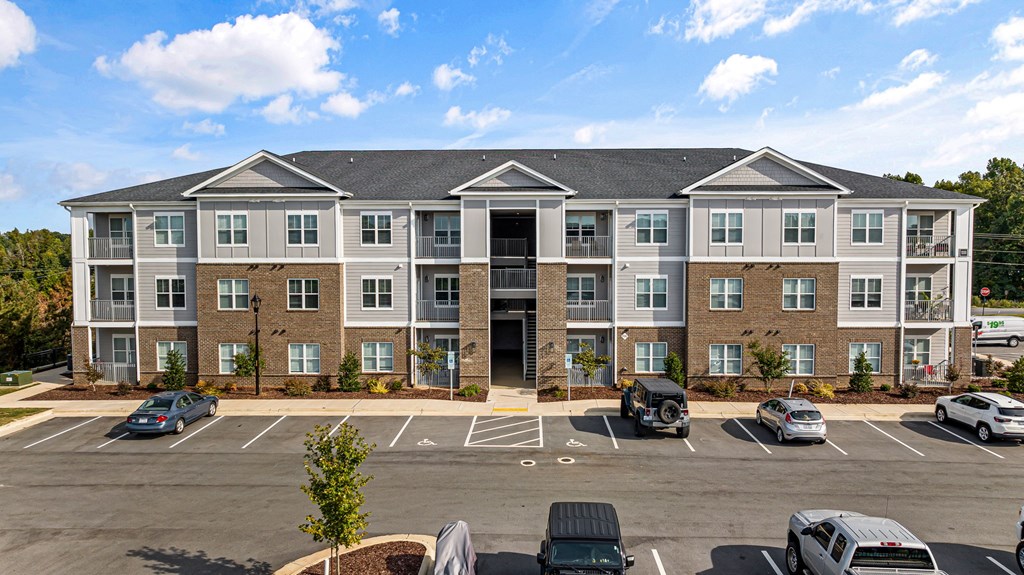 an apartment building in a parking lot with cars
