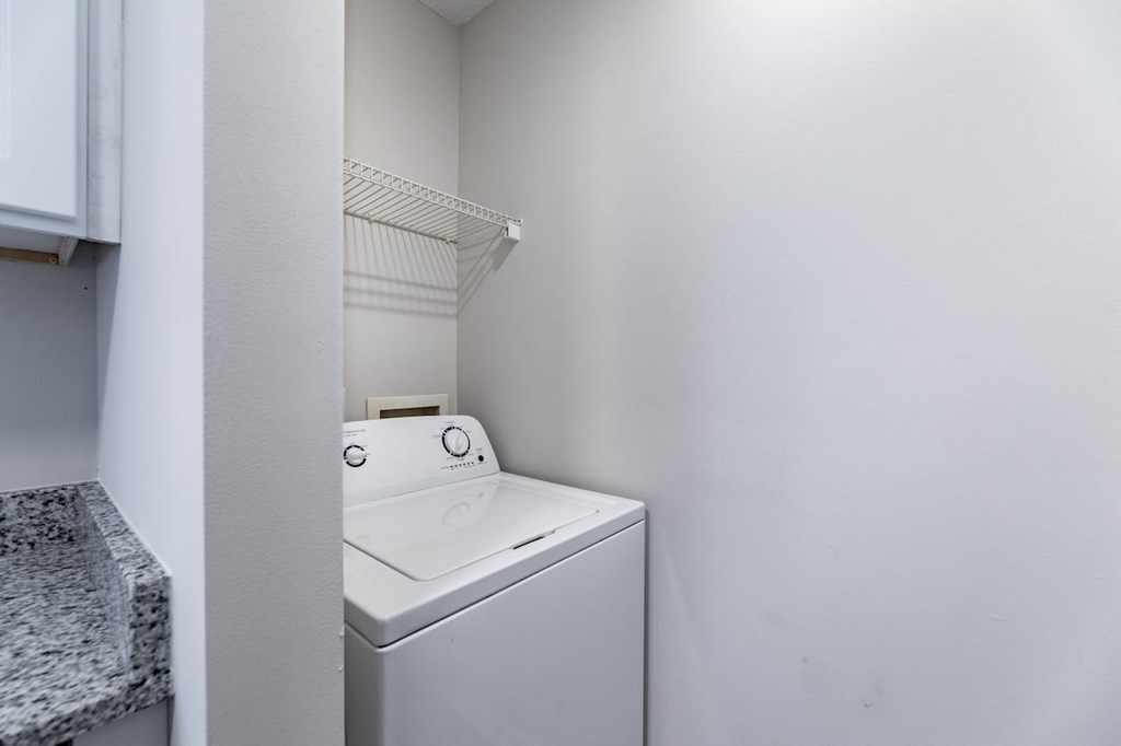 A white washing machine in a small laundry room.