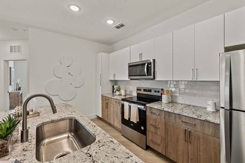 a modern kitchen with granite counter tops and stainless steel appliances