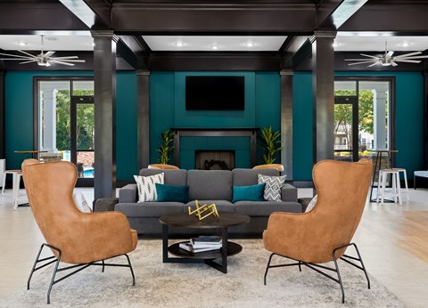 A living room with a grey couch, a brown chair and a fireplace.