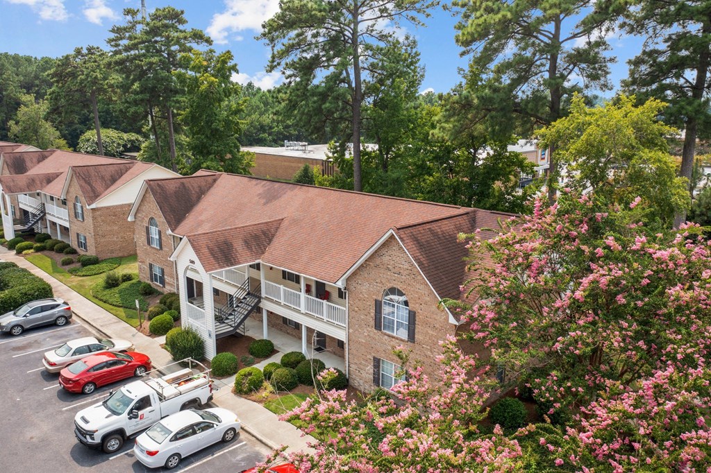 an aerial view of an apartment complex with cars parked in a parking lot