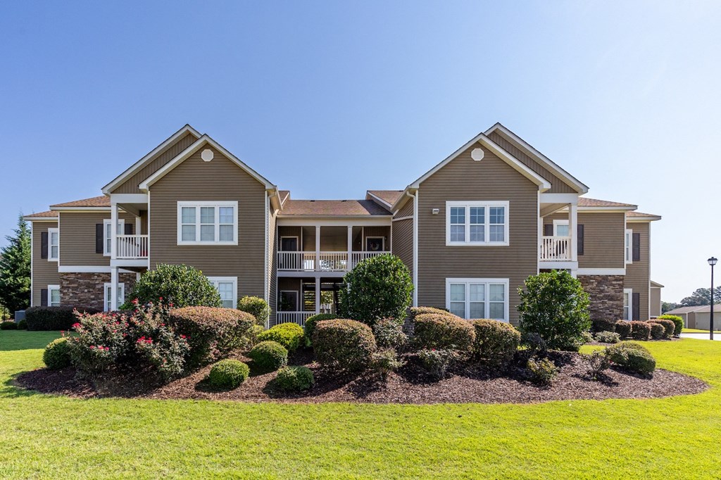 a large house with a lawn and landscaping in front of it