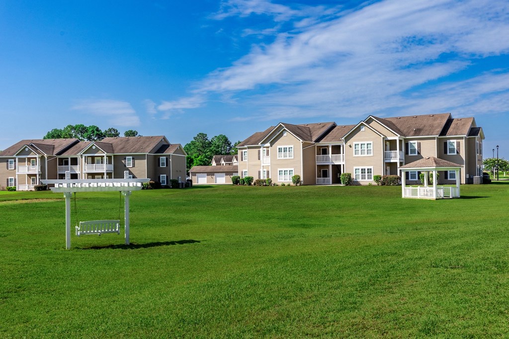 an open field with houses in the background