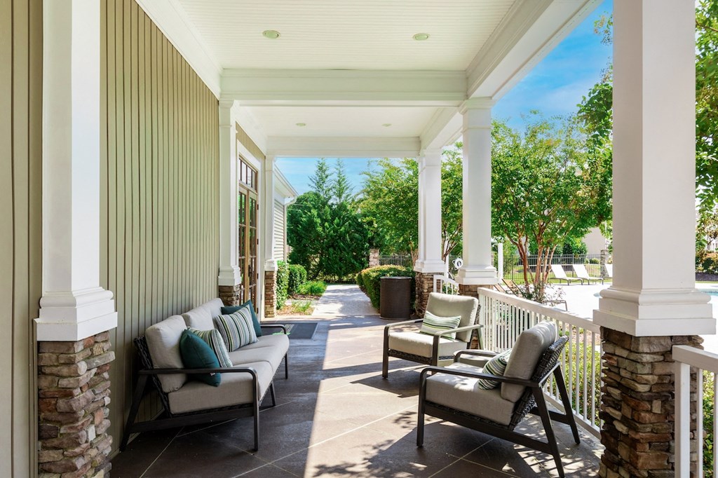 a covered porch with furniture and columns